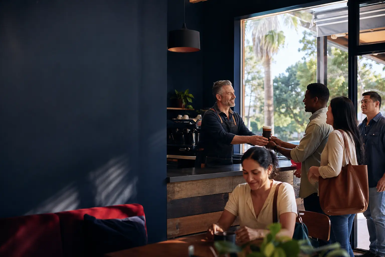 Coffee-shop owner welcoming a diverse group of returning customers