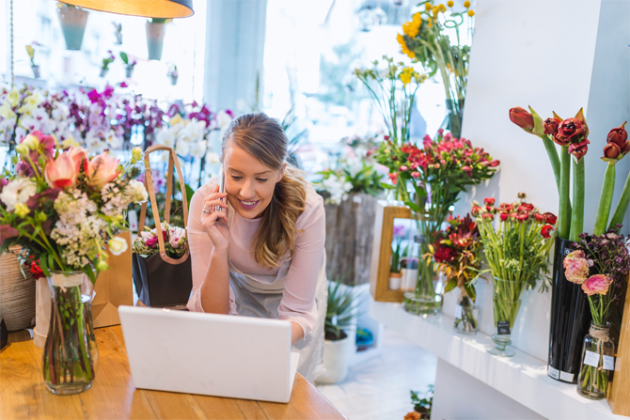 Woman on computer and Phone in flower shop